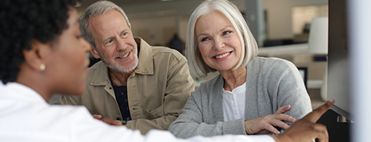 Image of senior adults speaking to a hearing care professional