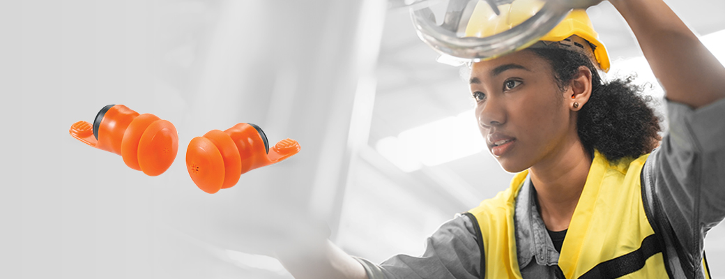 Image of worker operating machinery beside a pair of hearing protection devices