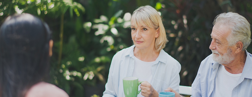 Image of woman looking distant while trying to listen to two other people