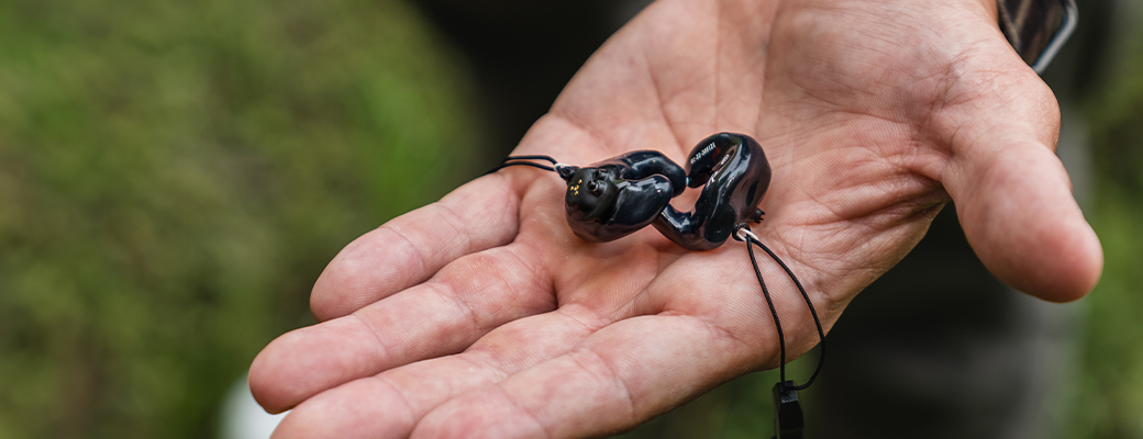 Image of hand holding two SoundGear Phantom hearing protection devices